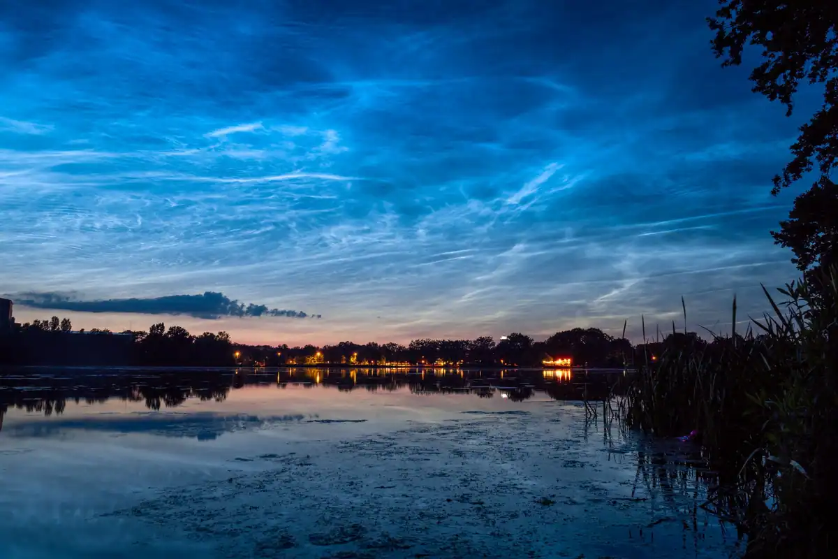 Lac la amurg cu nori colorați reflectați în apa liniștită