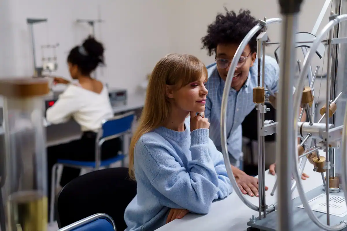 Studenți care fac împreună un experiment de fizică în laborator