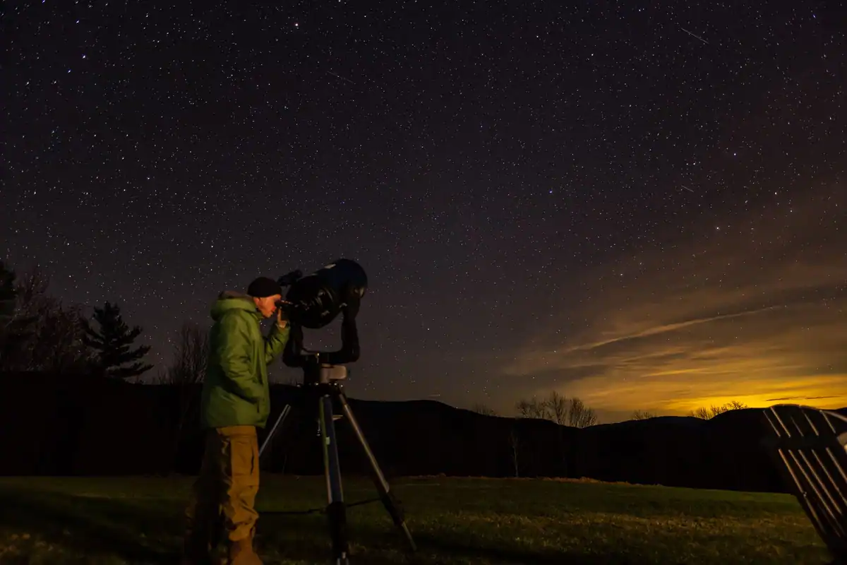 Om care privește cerul înstelat printr-un telescop pe o pajiște