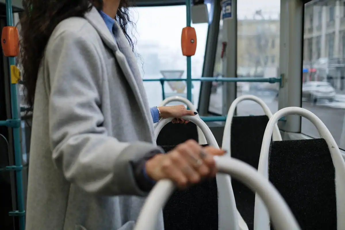 Pasager care se ține de bară într-un autobuz, exemplu de inerție