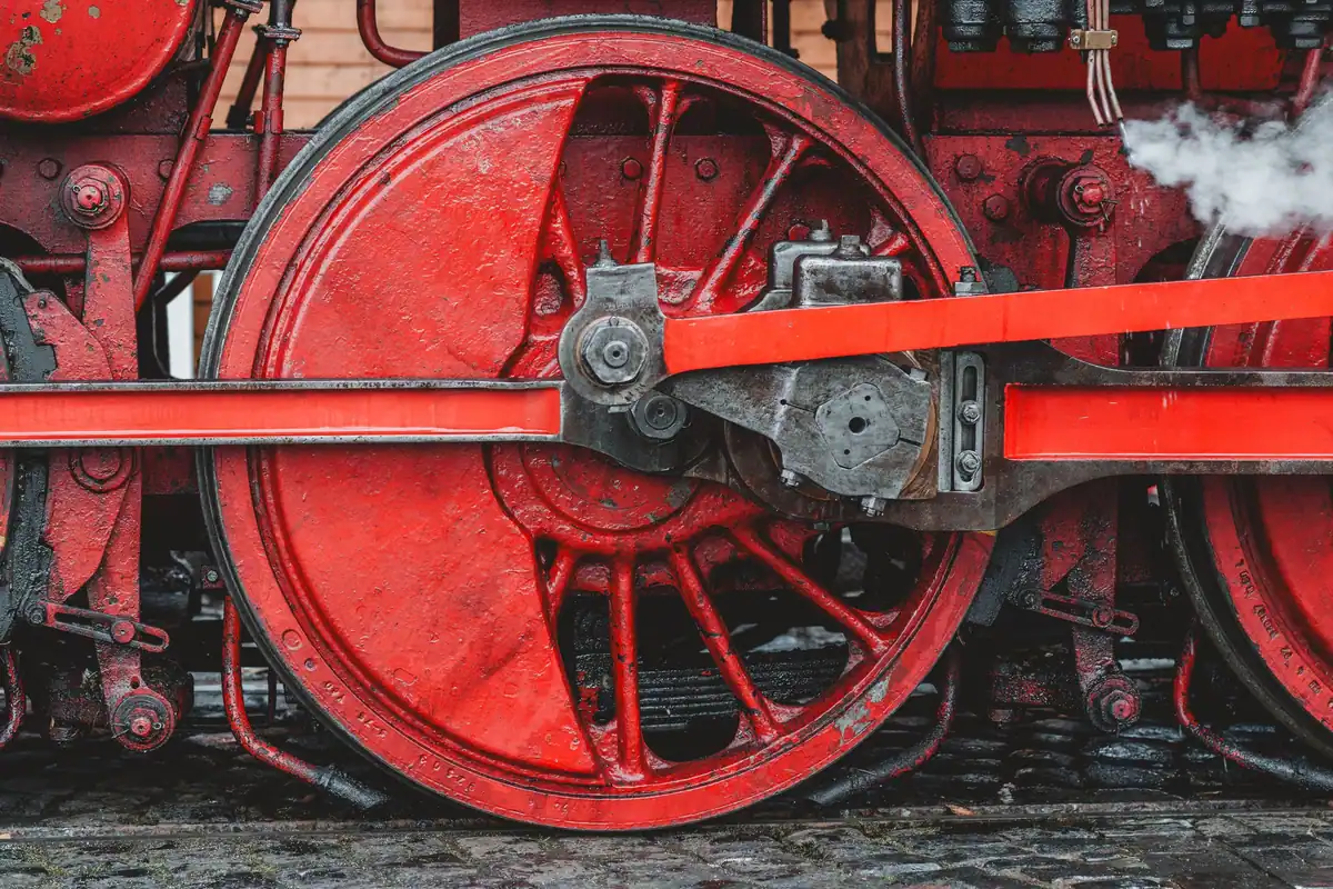 Roată roșie și pistoane ale unei locomotive cu abur